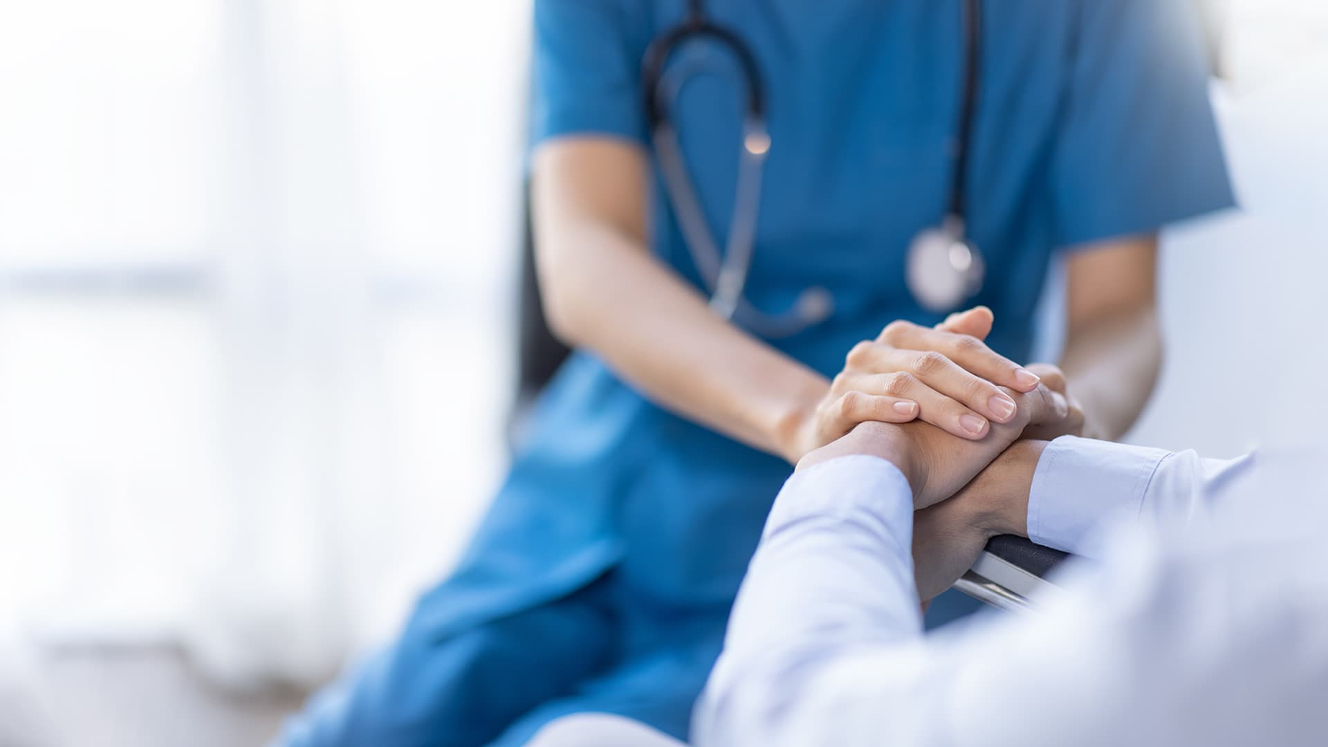 Nurse holding patient's hand